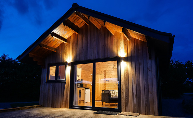 Luxury Lakeside Log Cabin Accommodation on Carp lake in Shropshire at night